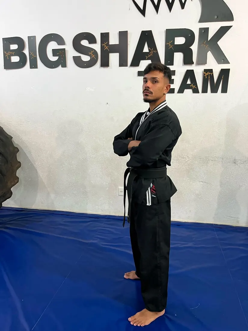 Professor Yuri Vargas de dobok preto e faixa preta de hapkido, de braços cruzados